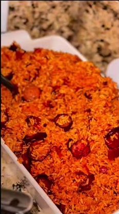 Large serving tray of seasoned red rice with sausage
